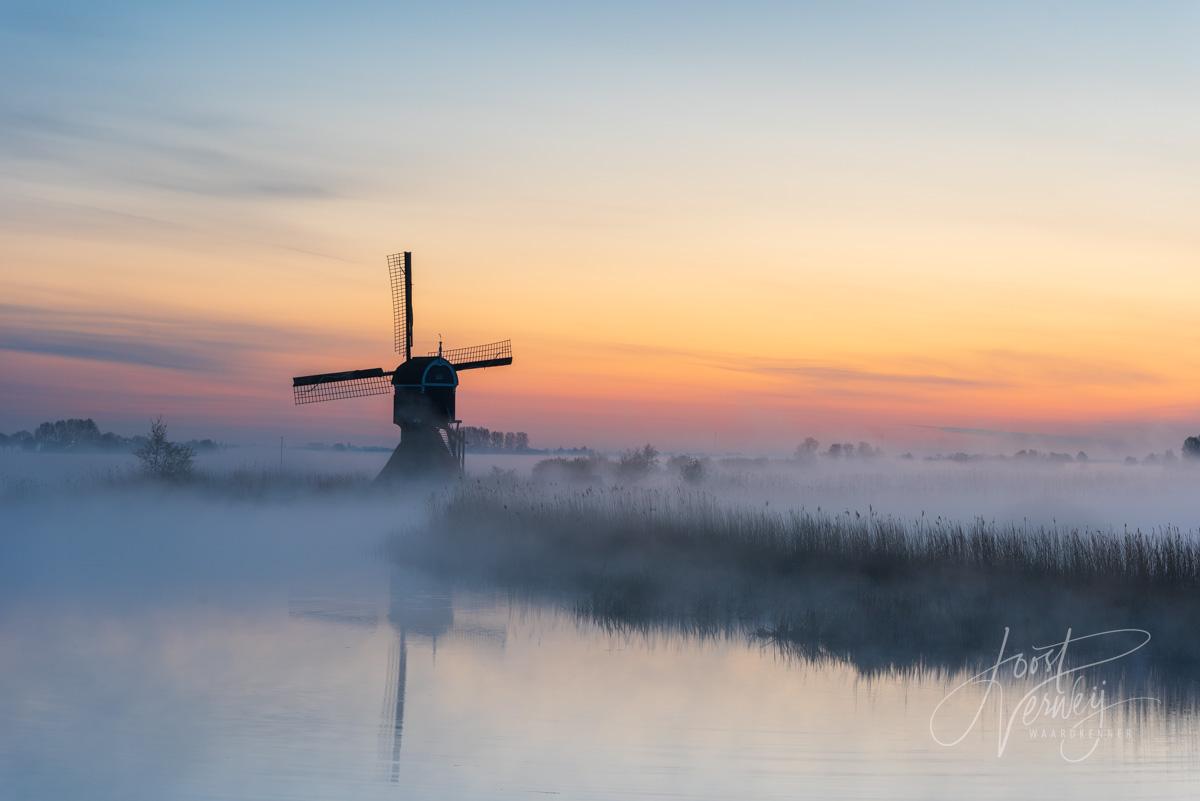 Broekmolen in mist bij zonsopkomst 