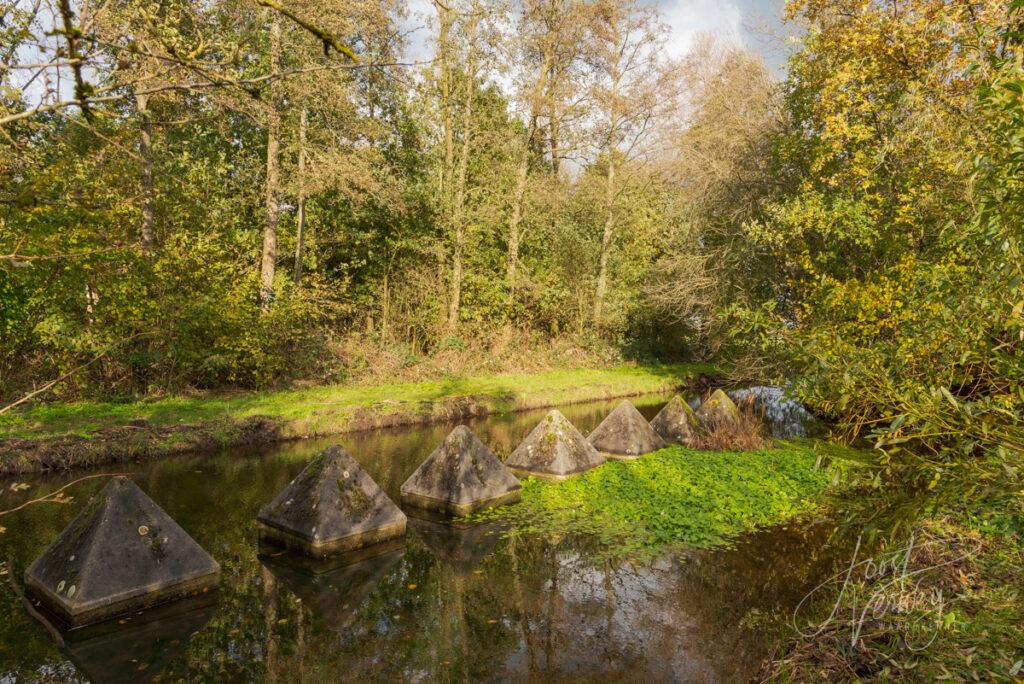 Kunstwerk van betonnen piramides in Alblasserbos